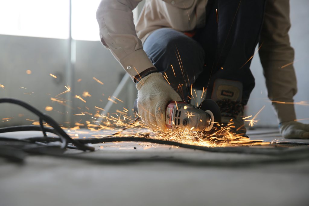 pexels photo 1216544 1216544 A skilled industrial worker uses a grinder creating a burst of sparks indoors.